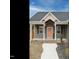 Welcoming front porch with peach-colored front door with storm door and green wreath at 216 Cross St, Sanford, NC 27330