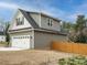 A 2-car garage with neutral siding and black roof is fenced-in with a wooden fence at 216 Cross St, Sanford, NC 27330