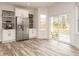 Bright kitchen area with stainless steel refrigerator, white cabinets, and sliding glass doors to the patio at 216 Cross St, Sanford, NC 27330