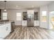 Modern kitchen featuring stainless steel refrigerator, white cabinets, and mosaic tile backsplash at 216 Cross St, Sanford, NC 27330