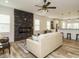 Bright living room with a stone fireplace, luxury vinyl flooring, and open access to the kitchen with a breakfast bar at 216 Cross St, Sanford, NC 27330