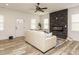 Bright living room with luxury vinyl flooring, a stone fireplace, modern ceiling fan, and a cozy seating area at 216 Cross St, Sanford, NC 27330