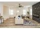 Bright open living room with luxury vinyl flooring and a modern ceiling fan and stone fireplace feature wall at 216 Cross St, Sanford, NC 27330