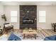 Open concept living room featuring a stone fireplace, luxury vinyl flooring, and lots of natural light at 216 Cross St, Sanford, NC 27330