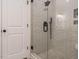 Close up of the walk-in shower featuring gray tiles and a frameless glass door at 216 Cross St, Sanford, NC 27330