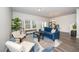 Bright living room with a blue sofa, large windows, and modern decor on a stylish area rug at 220 Brook Farm Ln, Fuquay Varina, NC 27526