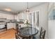 Bright kitchen with white cabinets, modern appliances, hardwood floors, and cozy breakfast nook at 25 Sandstone Ridge Dr, Durham, NC 27713