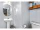 Half bathroom features a pedestal sink, a round mirror, and a toilet at 2506 Pepperstone Dr, Graham, NC 27253