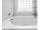Bathroom with tub and glass block window providing natural light at 2506 Pepperstone Dr, Graham, NC 27253