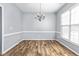 Dining room with wood-look flooring, chair rail detail, and a modern chandelier at 2506 Pepperstone Dr, Graham, NC 27253