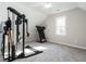 Finished attic space bedroom with neutral walls and carpet, featuring a workout set up and natural light at 2555 N Shiloh Rd, Garner, NC 27529