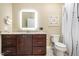 Bathroom vanity with granite countertop, dark wood cabinets, modern mirror, and toilet with privacy at 2941 Mt Vernon Church Rd, Raleigh, NC 27613