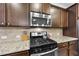 Close up on the stainless steel appliances in the kitchen with black gas cooktop and custom backsplash at 312 Princess Pl, Morrisville, NC 27560