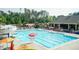 A large community pool with a slide, lifeguard, umbrellas, lounge chairs, and lots of trees at 3836 Prince Noah Loop, Wake Forest, NC 27587