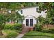 Charming exterior of a multi-level home showcasing brick steps, a covered entryway, and beautiful surrounding greenery at 3929 Browning Pl, Raleigh, NC 27609