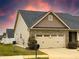 Exterior shot of a home highlighting the two-car garage, stone accents, and manicured lawn at 3947 Foxglove Trl, Burlington, NC 27215