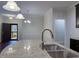 Close up on a kitchen island featuring a stainless steel sink and granite countertops, with a view of the dining room at 3947 Foxglove Trl, Burlington, NC 27215