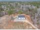 View of outbuilding with three garage doors surrounded by wooded acreage at 3958 Buckhorn Rd, Sanford, NC 27330