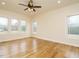 Spacious bedroom with hardwood floors, a ceiling fan, and bright windows showcasing natural light at 3958 Buckhorn Rd, Sanford, NC 27330