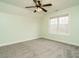 Spacious carpeted bedroom featuring a ceiling fan, natural light, and fresh paint at 3958 Buckhorn Rd, Sanford, NC 27330