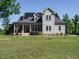 Charming two-story home featuring solar panels, a welcoming front porch and manicured landscaping at 3958 Buckhorn Rd, Sanford, NC 27330