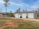 Detached three-car garage with roll-up doors, set alongside a small barn, offering ample storage and workspace at 3958 Buckhorn Rd, Sanford, NC 27330