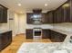 Well-lit kitchen showcases stainless steel appliances, dark cabinets, granite countertops, and hardwood floors at 3958 Buckhorn Rd, Sanford, NC 27330