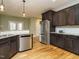 Bright kitchen features stainless steel appliances, dark cabinetry, granite countertops, and hardwood floors at 3958 Buckhorn Rd, Sanford, NC 27330