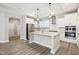 A modern kitchen featuring white cabinetry, an island, stainless steel appliances, and stylish pendant lighting at 470 Bramble Ln, Clayton, NC 27527