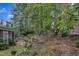 Secluded backyard with a terraced garden, mature trees, and partial fencing, providing privacy and beauty at 500 Creek Valley Dr, Fuquay Varina, NC 27526