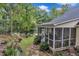 Backyard featuring a screened porch with seating, surrounded by lush landscaping and greenery at 500 Creek Valley Dr, Fuquay Varina, NC 27526