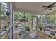 Relaxing screened porch with wicker furniture, ceiling fan, and peaceful backyard views at 500 Creek Valley Dr, Fuquay Varina, NC 27526