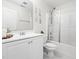 Modern bathroom features a white vanity, toilet, and shower-tub with glass door at 5841 Wynmore Rd, Raleigh, NC 27610