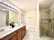 Bright bathroom features dual sink vanity, soaking tub, and glass enclosed shower at 5841 Wynmore Rd, Raleigh, NC 27610