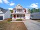 Charming two-story home with a welcoming front porch and red window shutters at 5841 Wynmore Rd, Raleigh, NC 27610