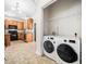Well-lit kitchen featuring stainless steel appliances, wood cabinets, and laundry room at 5841 Wynmore Rd, Raleigh, NC 27610