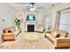 Bright living room with neutral carpet, sofas, fireplace, and ceiling fan at 5841 Wynmore Rd, Raleigh, NC 27610
