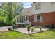 A two-story brick home with a screened-in porch and patio, surrounded by lush greenery at 612 W Chisholm St, Sanford, NC 27330