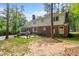 Expansive backyard with a two-story brick home, patio, and mature trees at 612 W Chisholm St, Sanford, NC 27330