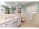 Classic bathroom with yellow tile, white vanity, and large mirror at 612 W Chisholm St, Sanford, NC 27330