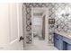 Bathroom featuring patterned wallpaper, view of the toilet and shower, and a blue vanity at 612 W Chisholm St, Sanford, NC 27330