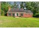 Charming brick home with symmetrical design, lush lawn, and mature trees at 612 W Chisholm St, Sanford, NC 27330