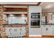Updated kitchen with brick surround cooktop, stainless appliances, and wood floors at 612 W Chisholm St, Sanford, NC 27330