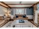 Relaxing living room space with exposed beams, hardwood floors, a brick fireplace, and comfortable seating at 612 W Chisholm St, Sanford, NC 27330