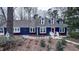 Charming blue home featuring a red door and dormer windows, complemented by mature trees and a landscaped front yard at 6317 Lakeland Dr, Raleigh, NC 27612