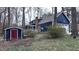 An exterior view of a two-story home with an attached garage, screened-in porch, fenced yard, and wooden storage shed at 6317 Lakeland Dr, Raleigh, NC 27612