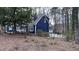 Picturesque blue house showcasing meticulous landscaping, lush trees, and a cozy sunroom to enhance outdoor living at 6317 Lakeland Dr, Raleigh, NC 27612