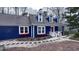 Quaint blue two-story home with white trim and red accents offers a welcoming front entrance with a landscaped yard at 6317 Lakeland Dr, Raleigh, NC 27612