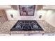 Close-up view of a black stovetop with stylish knobs set atop gleaming granite countertops in a modern kitchen design at 6317 Lakeland Dr, Raleigh, NC 27612