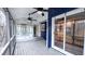 View of the screened porch with ceiling fans, gray wood flooring, and access to the sunroom via a set of steps at 6317 Lakeland Dr, Raleigh, NC 27612